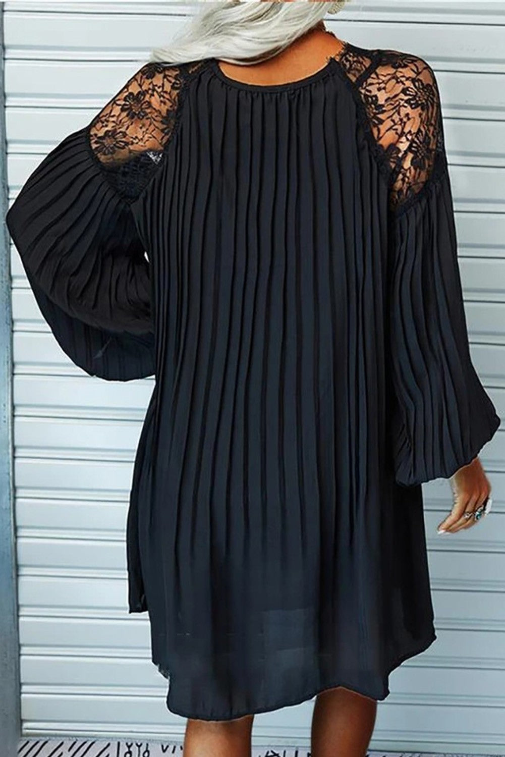 Elegant black pleated mini dress with lace inserts, featuring long loose sleeves and a 'V' neckline, perfect for various occasions.