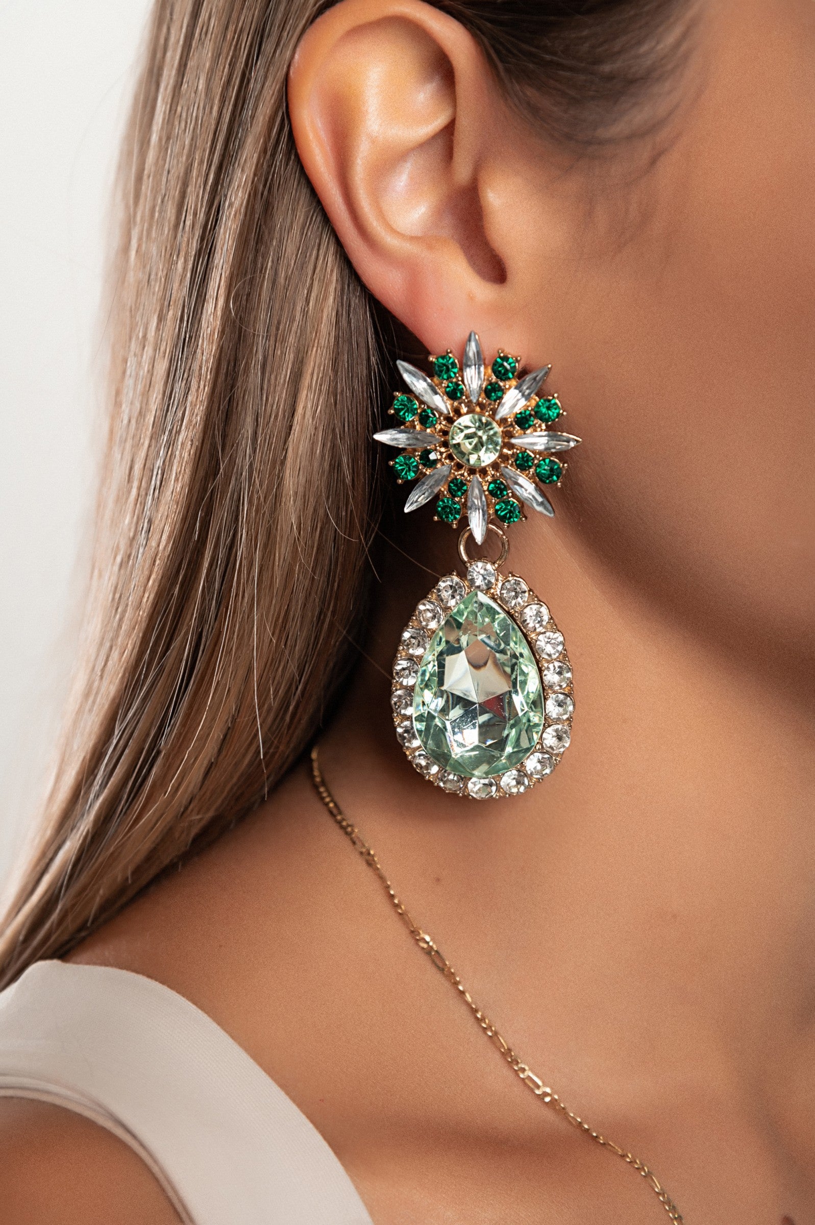 Elegant green rhinestone chandelier earrings with intricate detailing, perfect for enhancing any outfit.