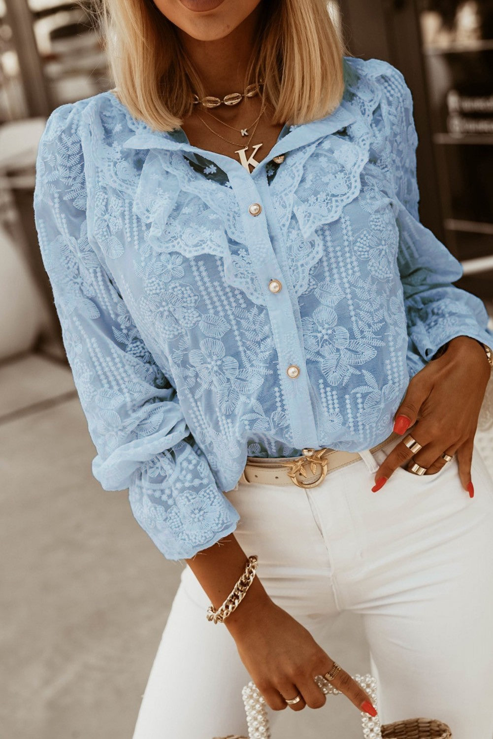 Elegant light blue shirt with embroidery and frills, featuring long sleeves and button closure, perfect for stylish outfits.