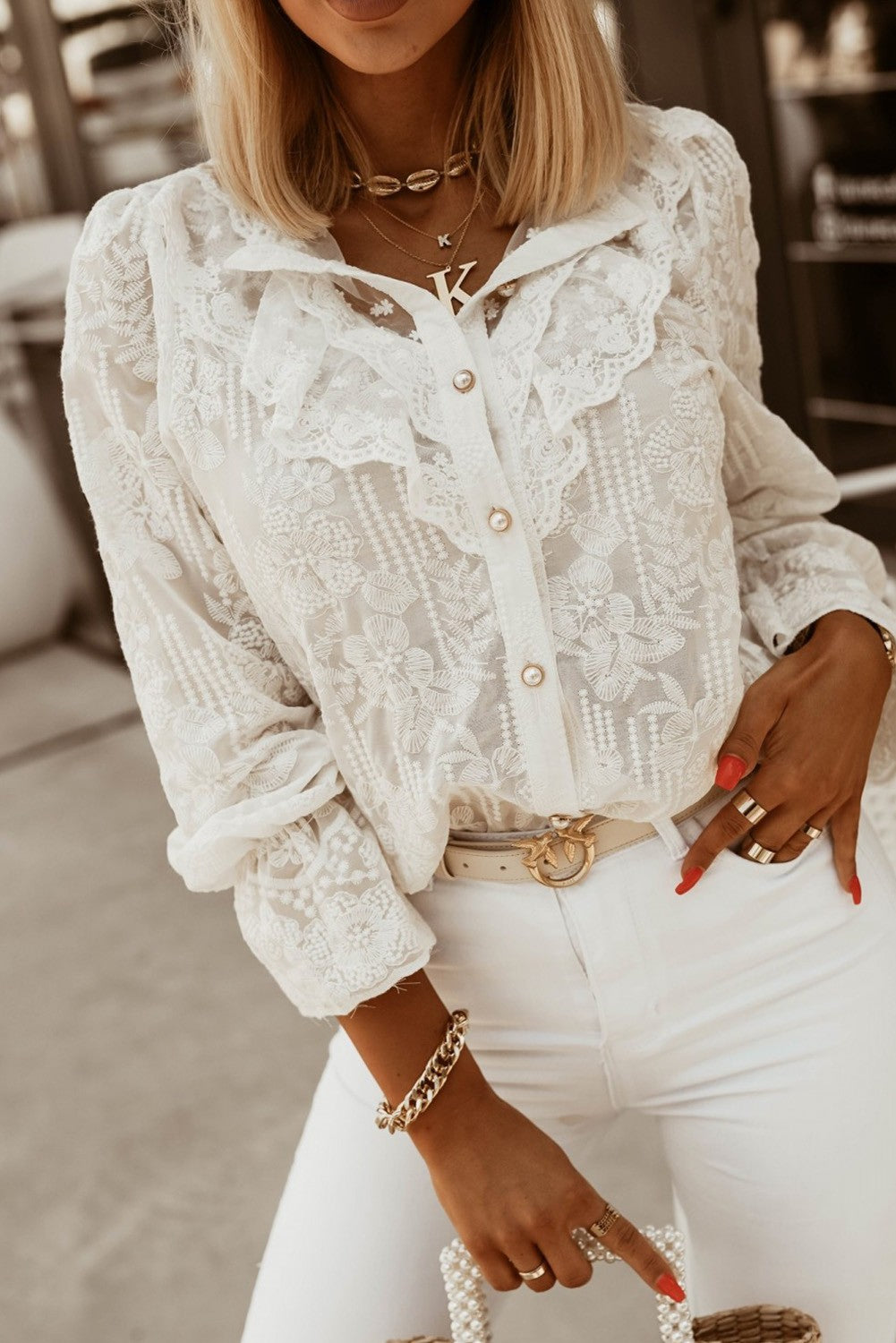 Elegant white shirt with embroidery and ruffles, featuring long sleeves and button closure.