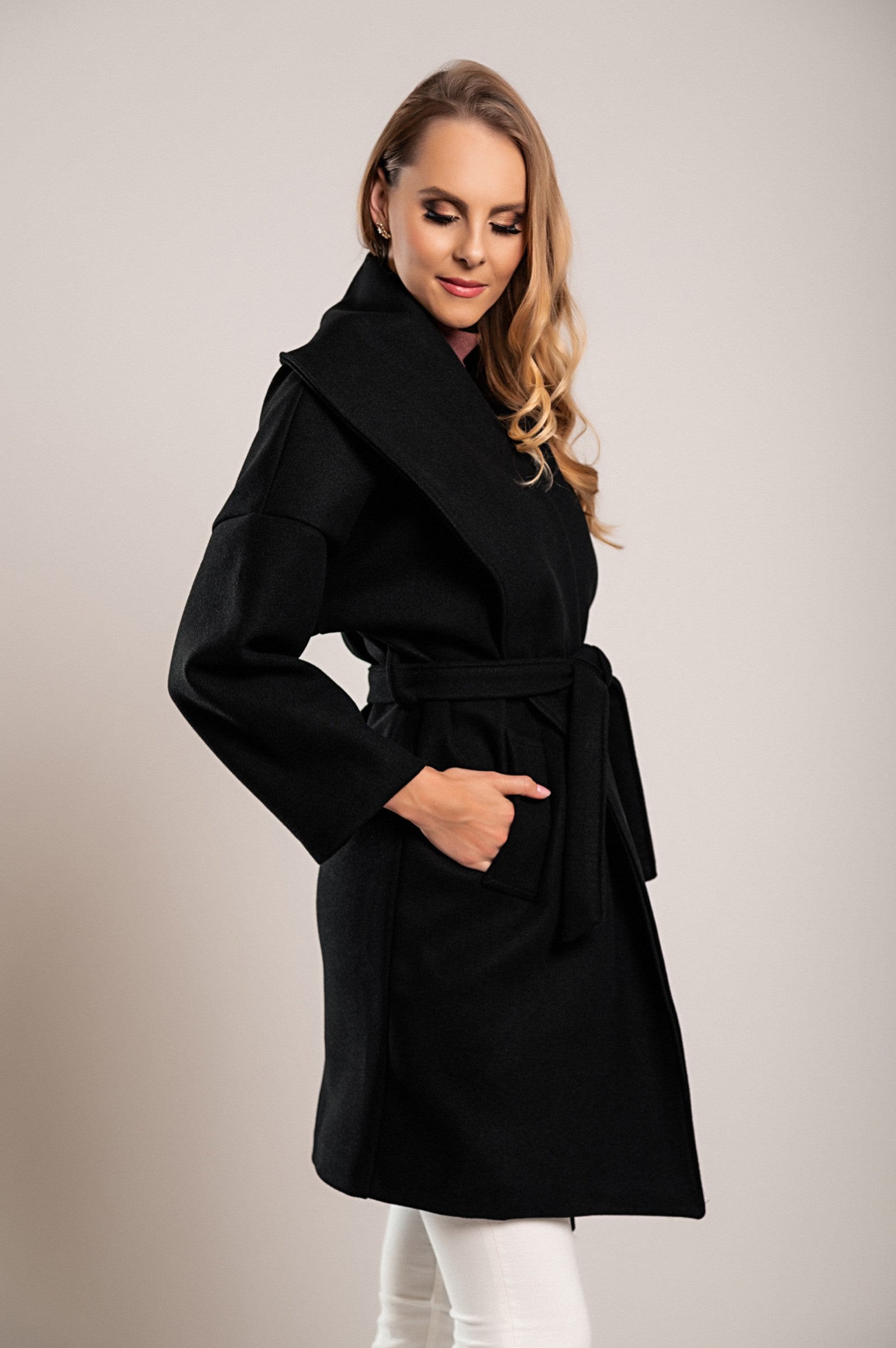 Elegant black short coat featuring a wide lapel collar and decorative belt, made from soft polyester fabric.