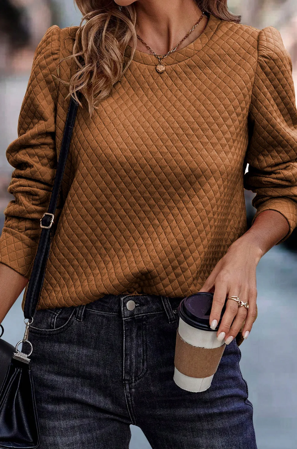 Elegant brown top featuring quilted detail, round neck, and long sleeves, made from soft fabric for comfort.