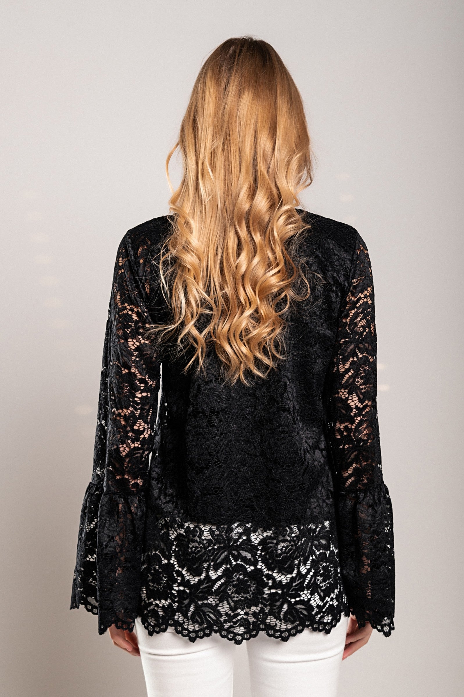 Elegant black transparent lace blouse with long sleeves and round neckline, showcasing delicate lace details.