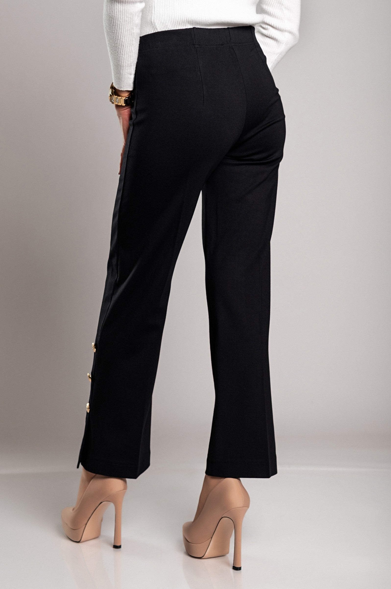 Elegant black trousers featuring decorative buttons and an elasticated waist, designed for comfort and style.