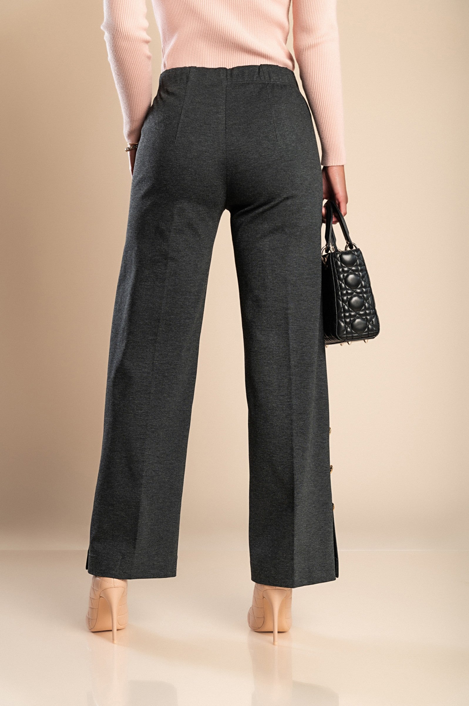 Elegant grey trousers with decorative buttons and elasticated waist, showcasing a stylish and comfortable design.