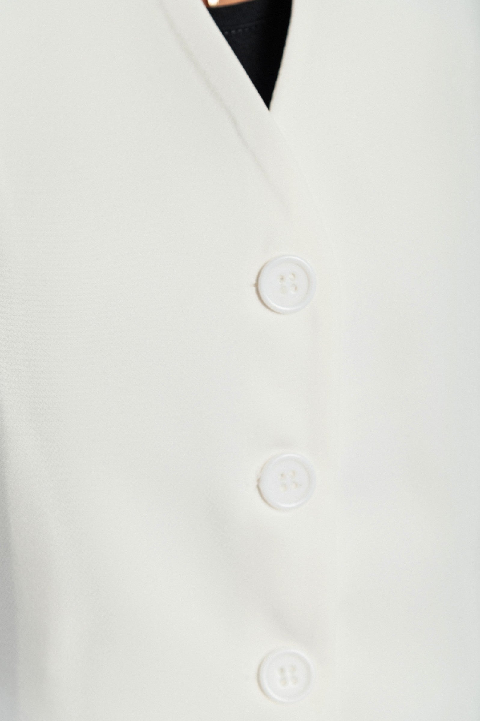 Elegant white vest with buttons, featuring a V-neckline and decorative side pockets, fully lined and made in Italy.