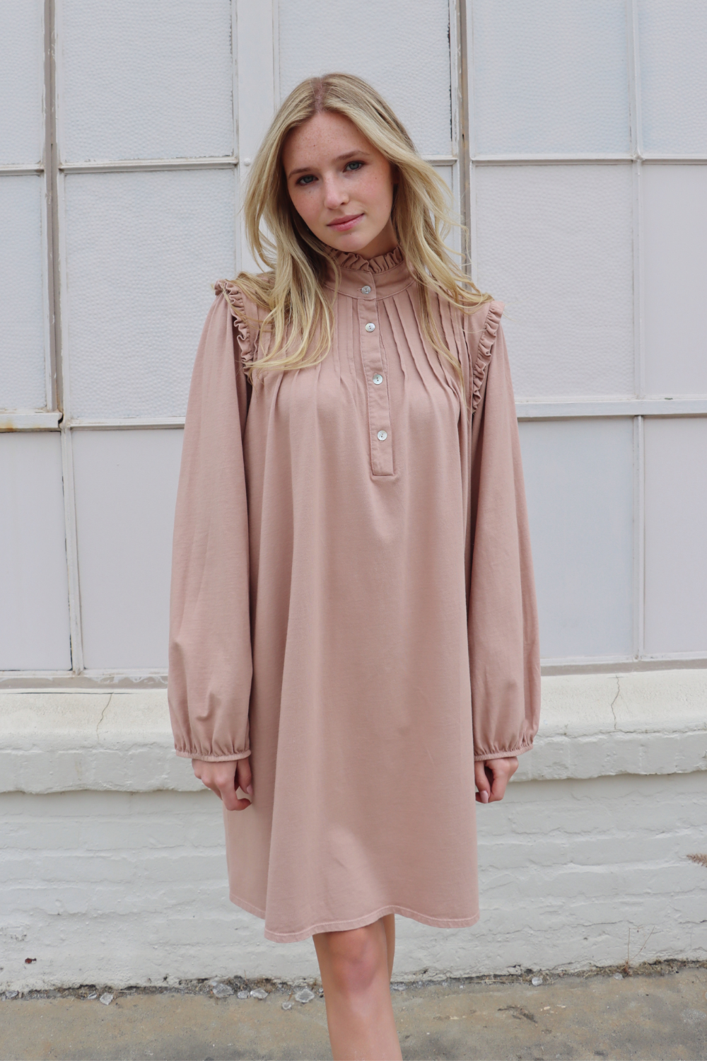 A stylish knee-length Embrace Dress featuring intricate neckline and shoulder details, made from 100% organic cotton in olive and rose pink colors.