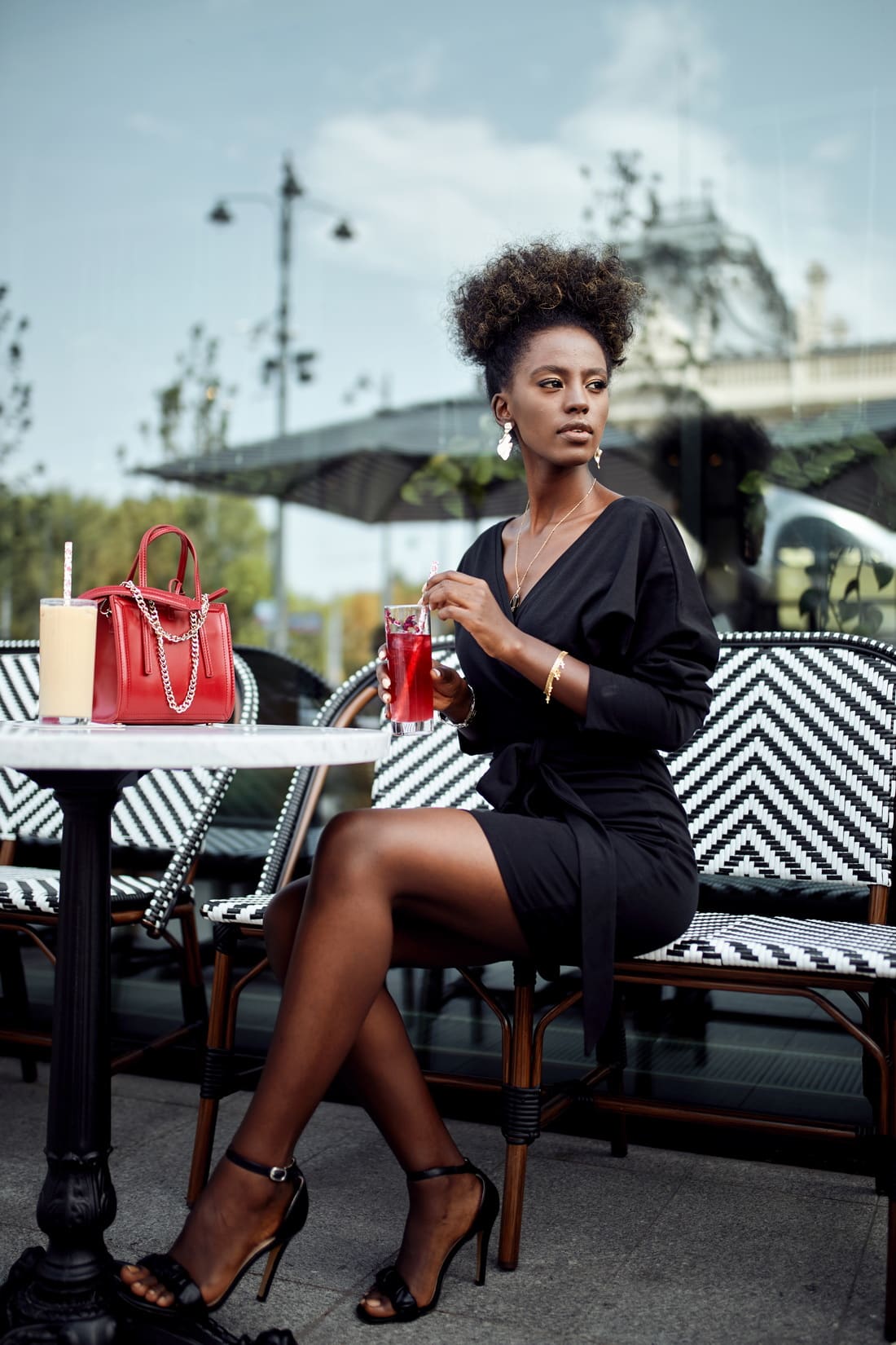 Elegant black envelope dress with asymmetric bottom, featuring V-neckline and tulip-shaped design.