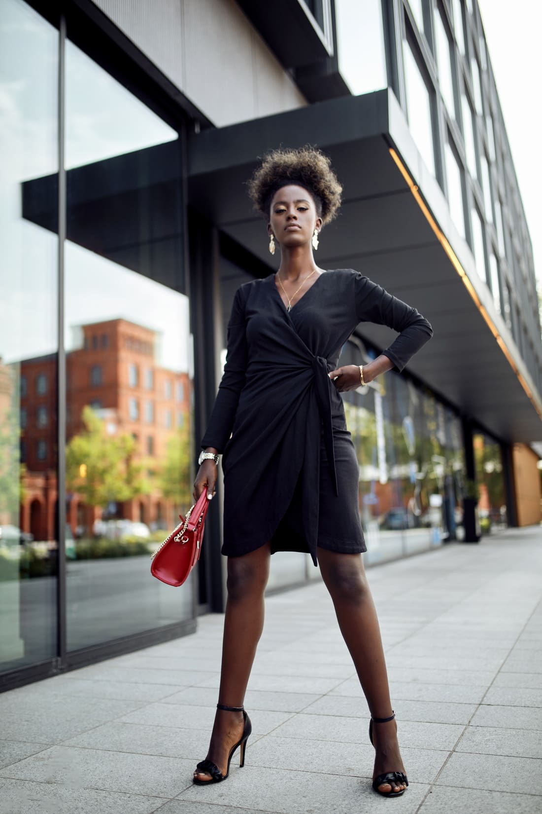 Elegant black envelope dress with asymmetric bottom, featuring V-neckline and tulip-shaped design.