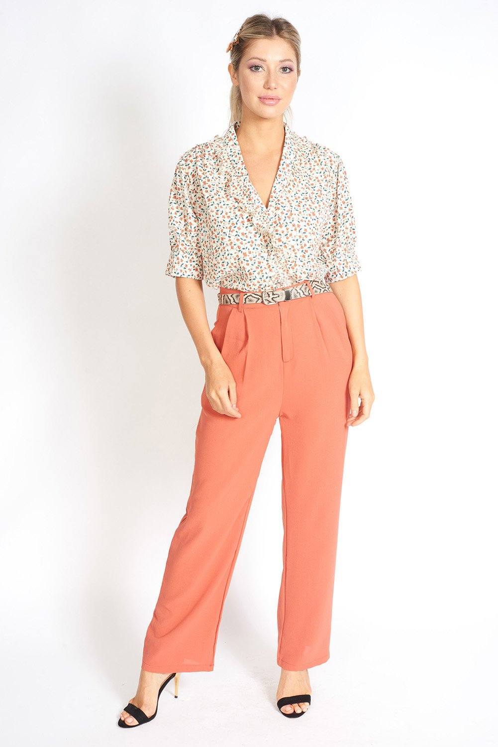 Essential High Waisted Suit Pants in a stylish setting, showcasing pleated detailing and side pockets.