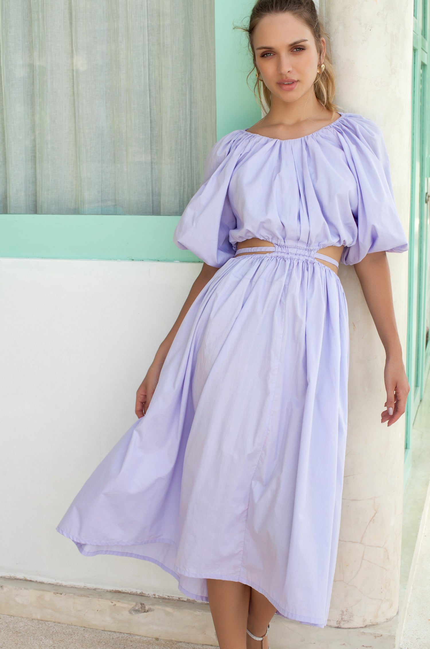 A stylish Eva Poplin Cotton Cutout Midi Dress featuring a voluminous skirt, puff sleeves, and elegant cutouts at the waist, available in multiple colors.