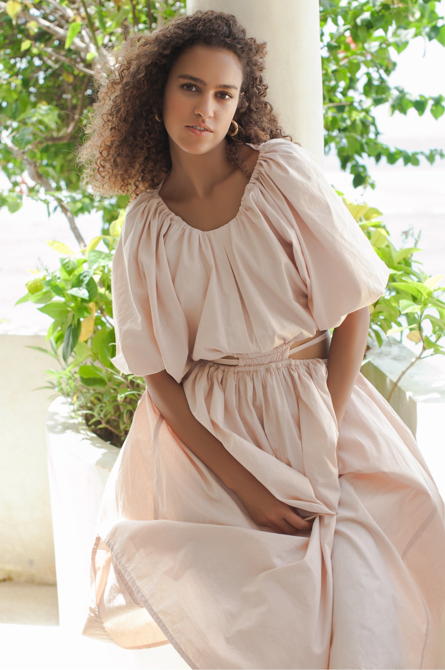 A stylish Eva Poplin Cotton Cutout Midi Dress featuring a voluminous skirt, puff sleeves, and elegant cutouts at the waist, available in multiple colors.