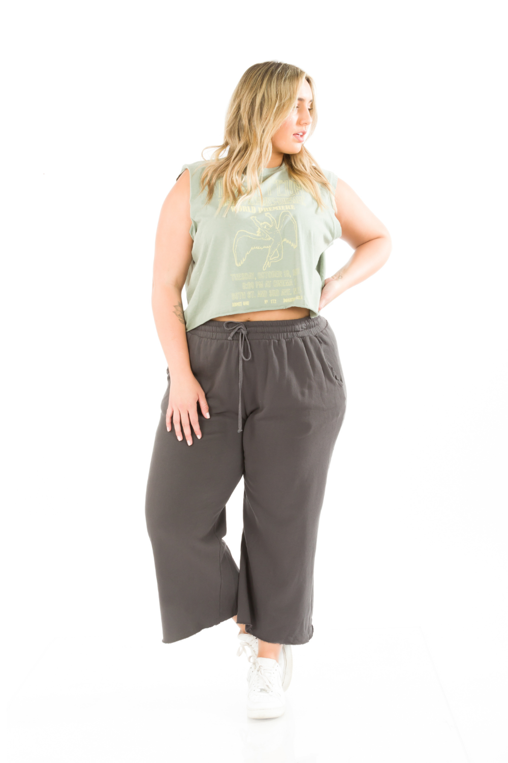 A pair of slouchy, cropped Everyday Pants in washed black with a drawstring waist and pockets, showcasing a relaxed fit and flared raw cut hem.