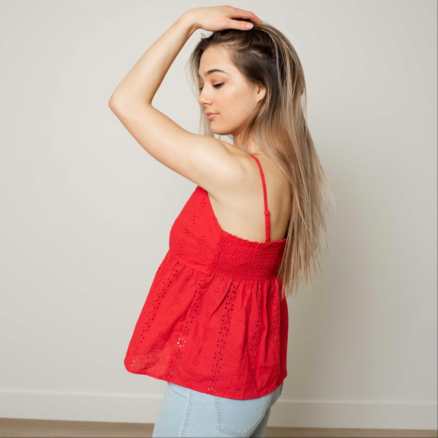 A stylish Eyelet V-neck Flounced Cami Top featuring a tiered silhouette and ruffled hem, perfect for summer wear.