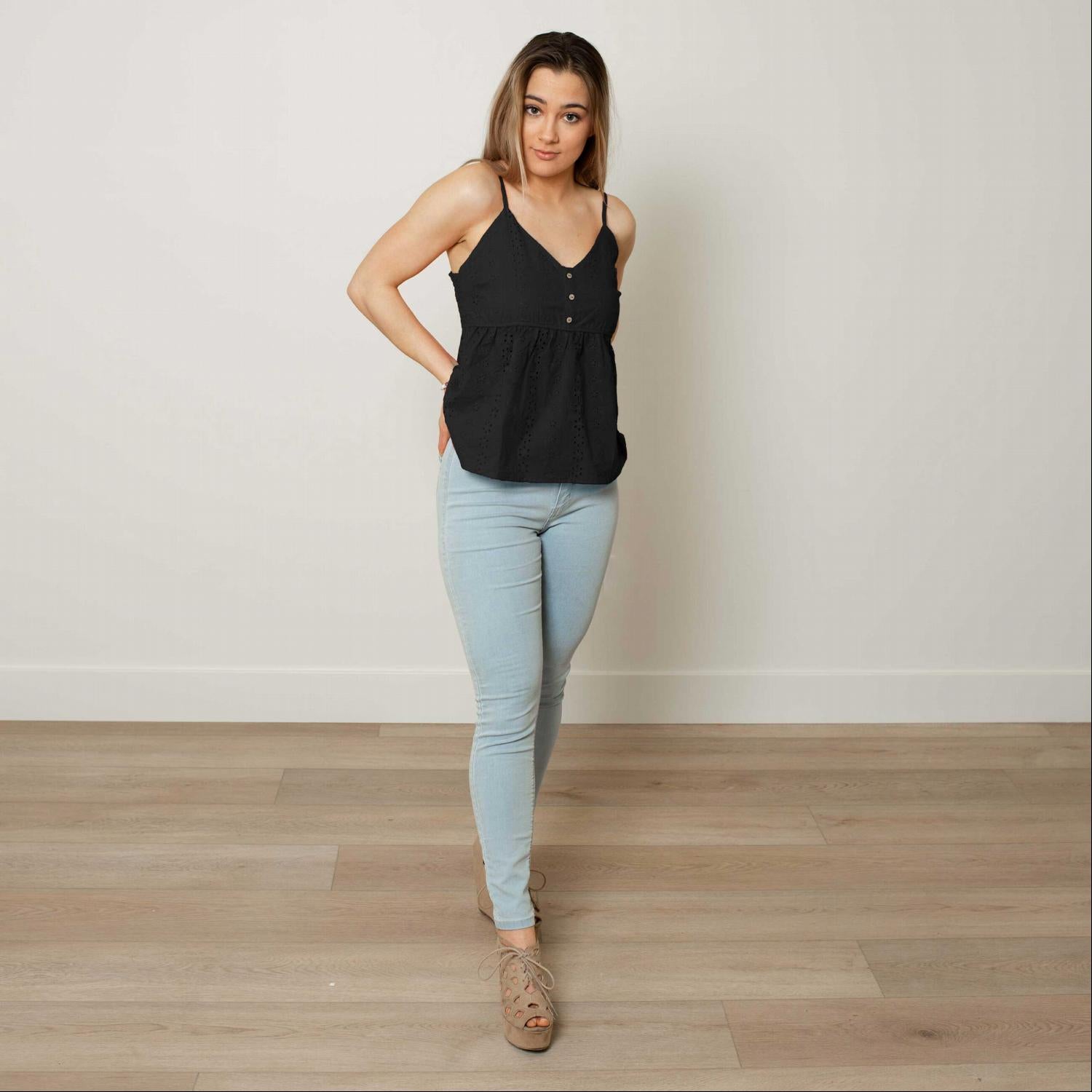 A stylish Eyelet V-neck Flounced Cami Top featuring a tiered silhouette and ruffled hem, perfect for summer wear.