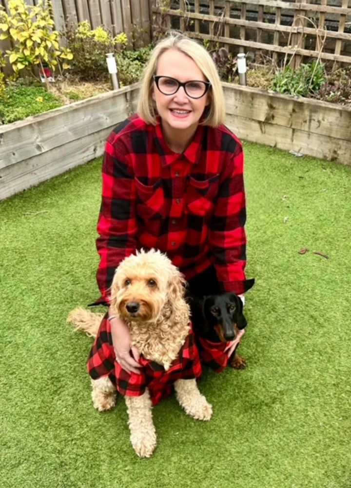 A family wearing matching flannel shirts with their dogs, showcasing the cozy and stylish design of the pet shirts.