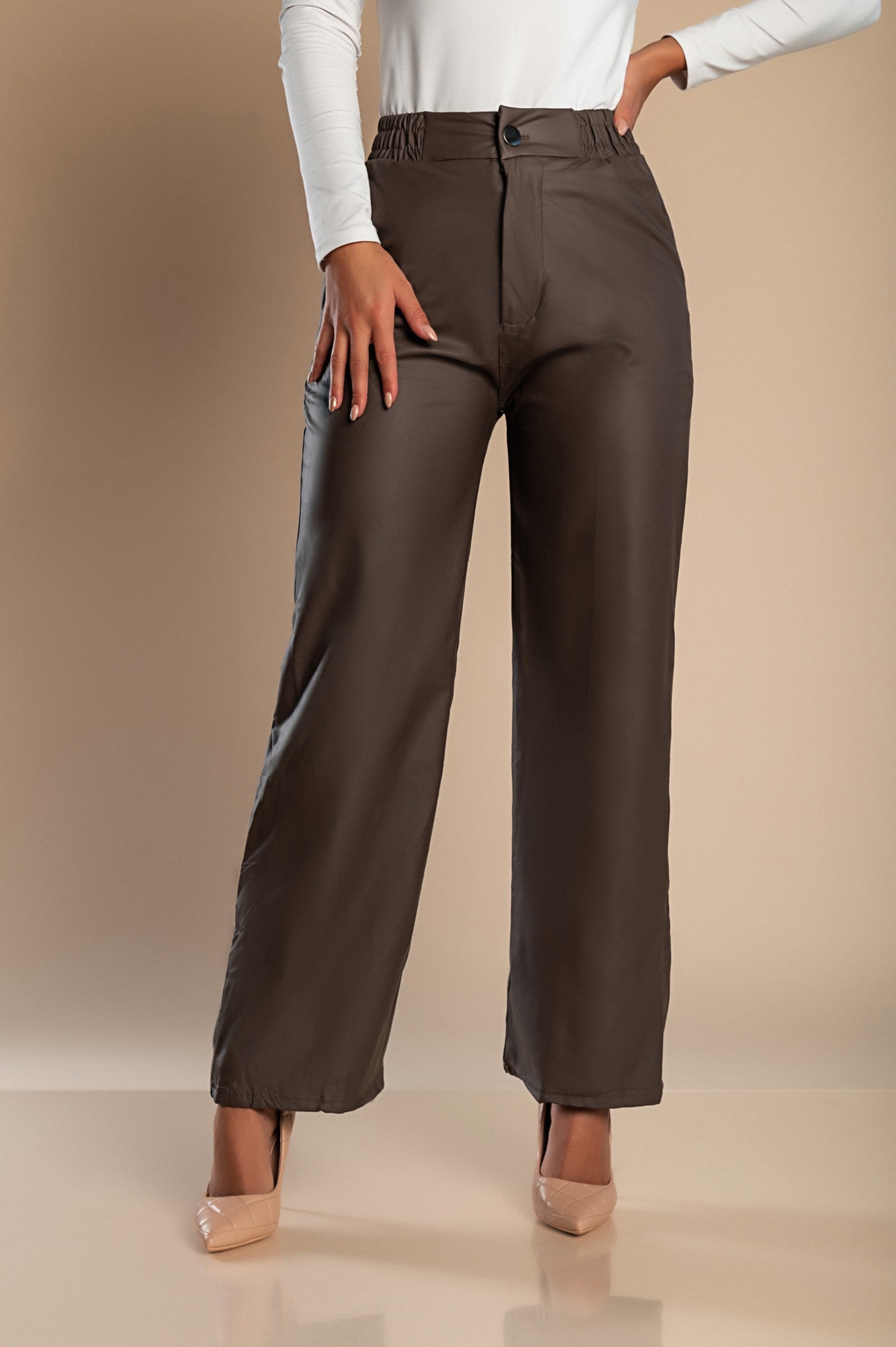 Mud-colored imitation leather fashion pants with side pockets, button and zipper closure, and elastic waist, designed for comfort and style.