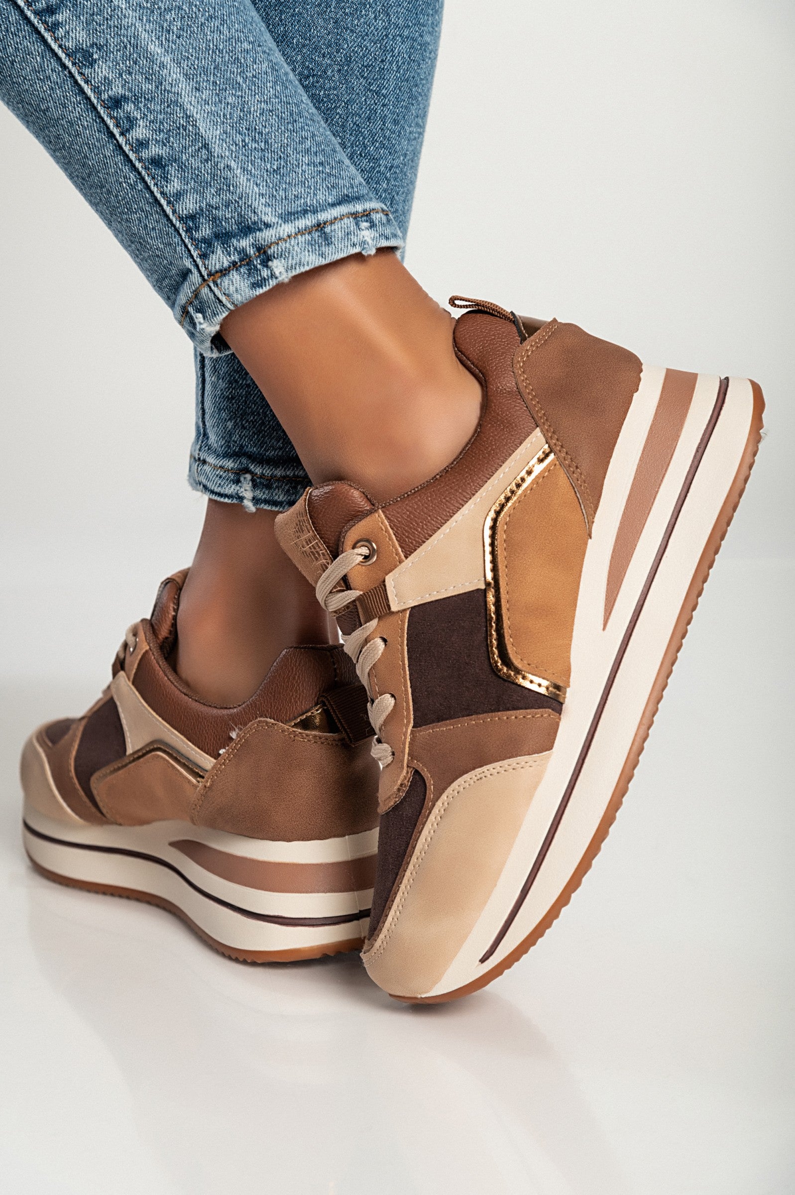 Multicolor fashion sneakers with raised sole, lace-up closure, and round toe design in brown color.