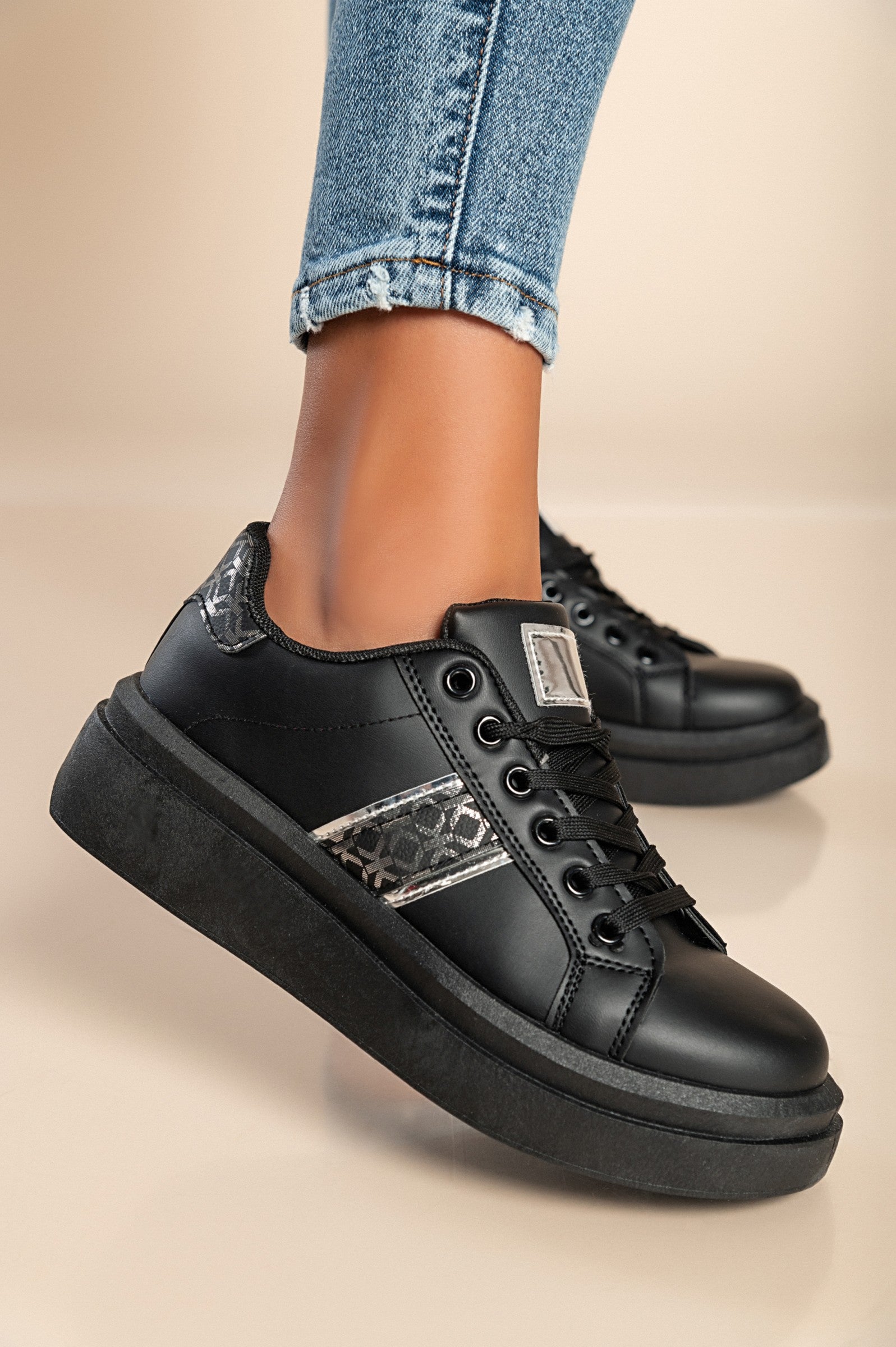 Black fashion sneakers with flat sole, round toe, and lace-up closure, made of high-quality faux leather.