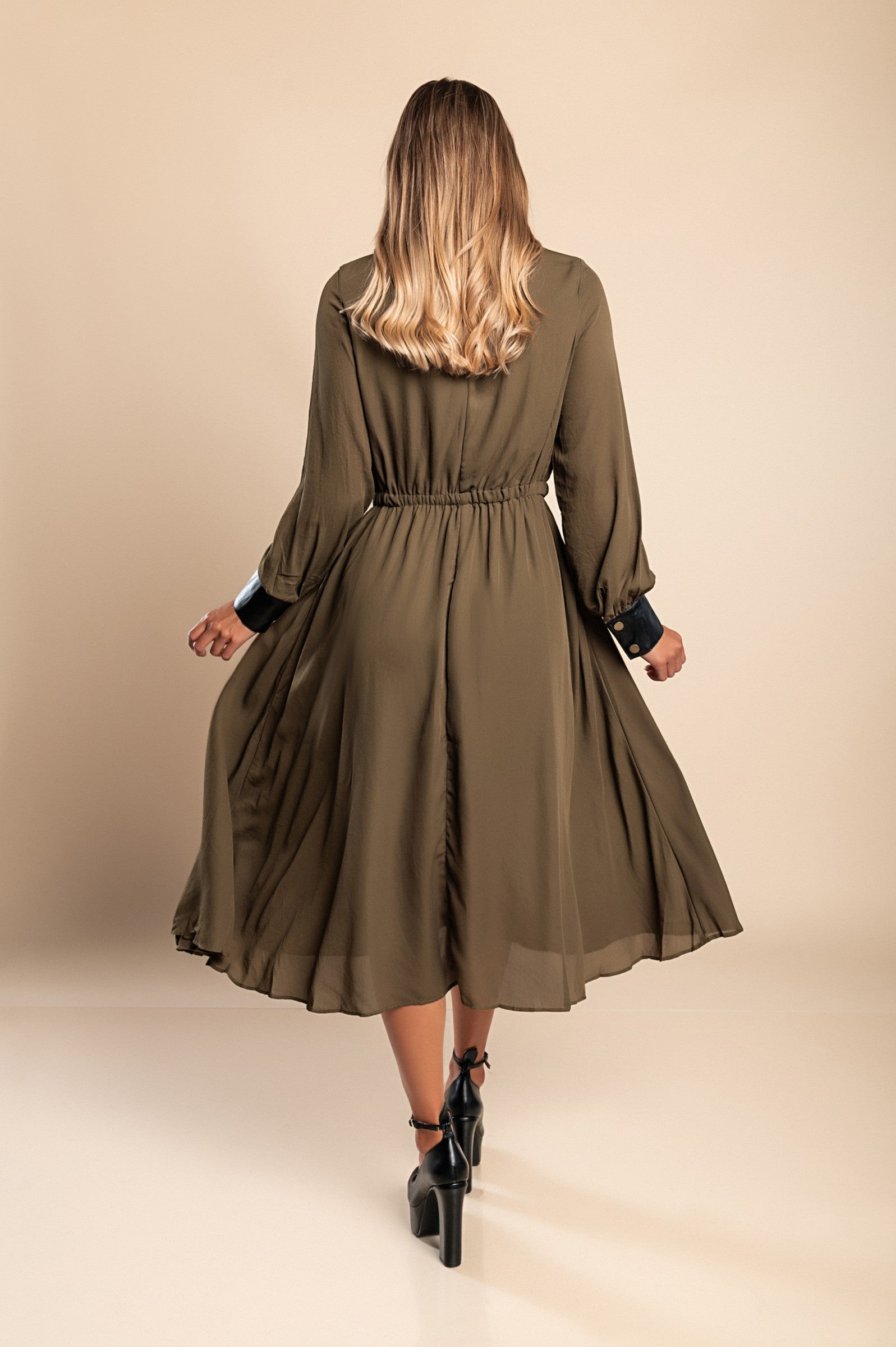 Olive green midi dress with faux leather details, featuring a round neckline, long sleeves, and an elastic waist, perfect for stylish occasions.