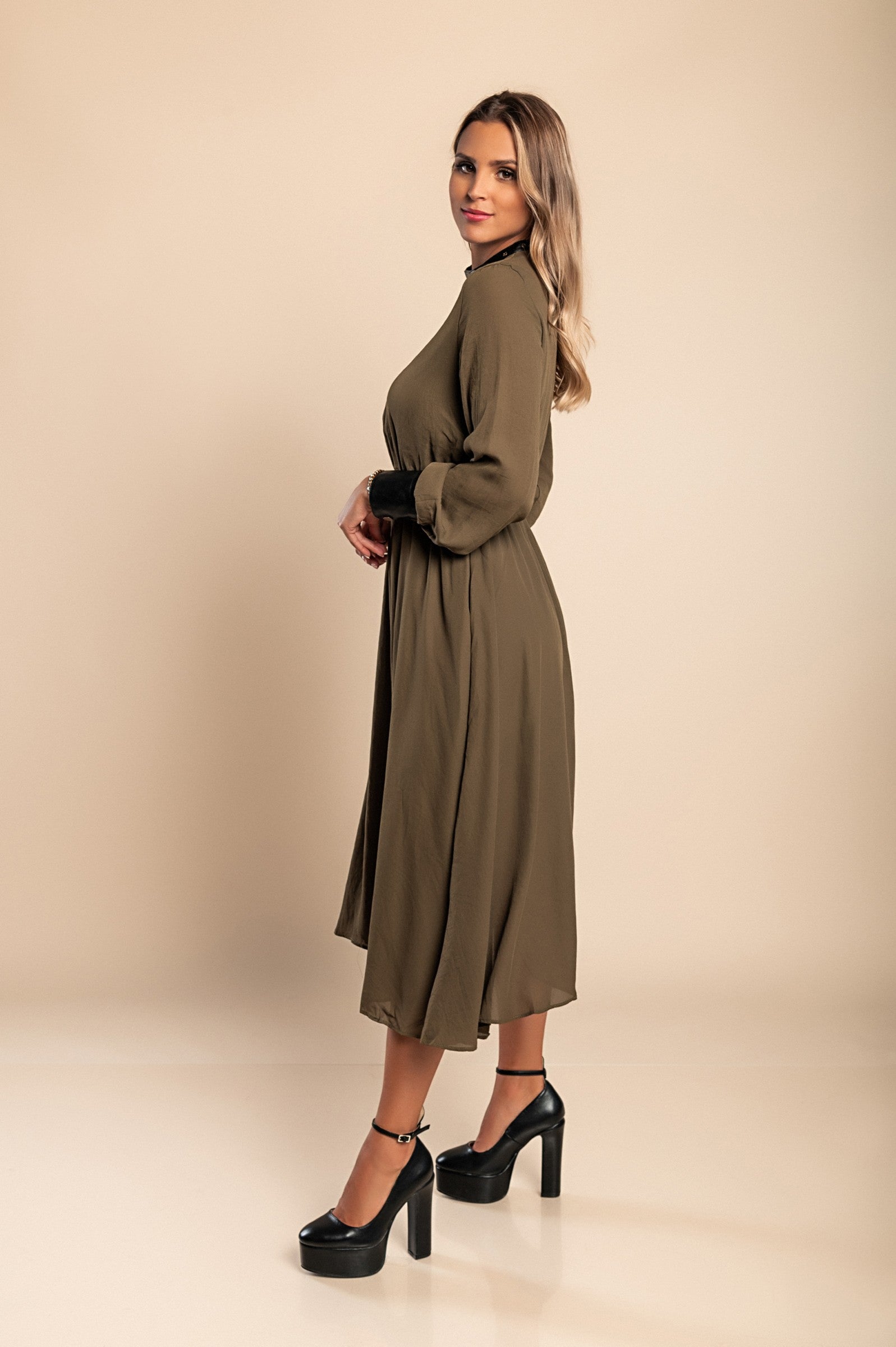 Olive green midi dress with faux leather details, featuring a round neckline, long sleeves, and an elastic waist, perfect for stylish occasions.