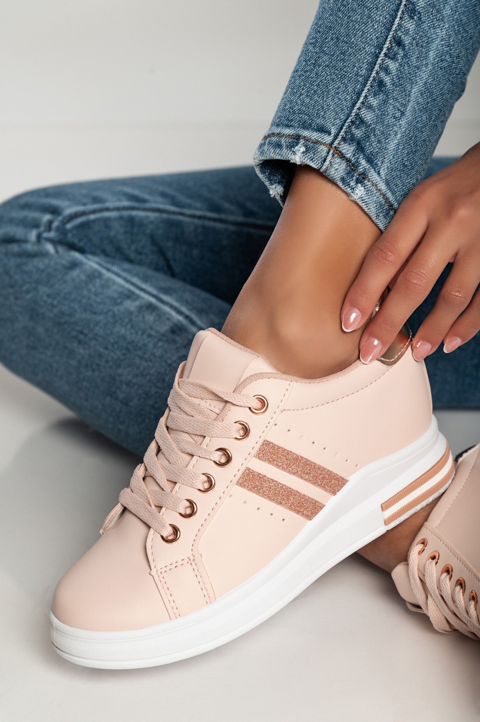 Stylish pink faux leather sneakers with round toe and laces, featuring a raised sole for added comfort.