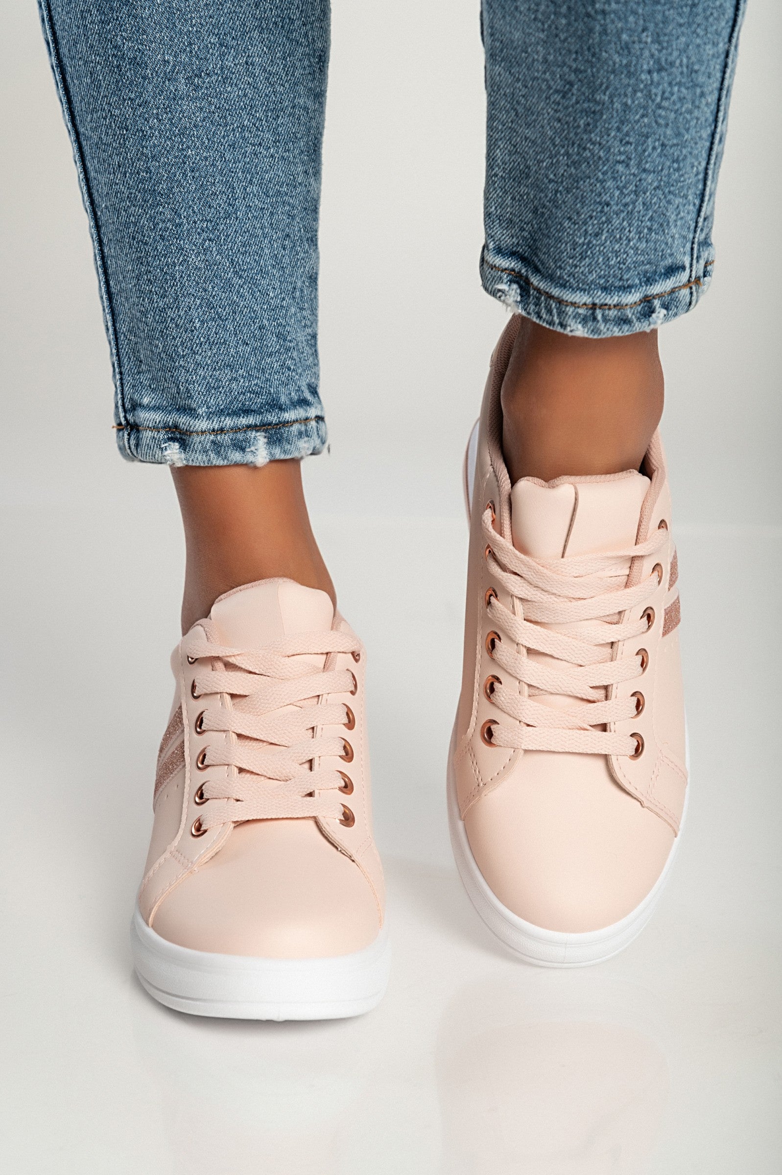 Stylish pink faux leather sneakers with round toe and laces, featuring a raised sole for added comfort.