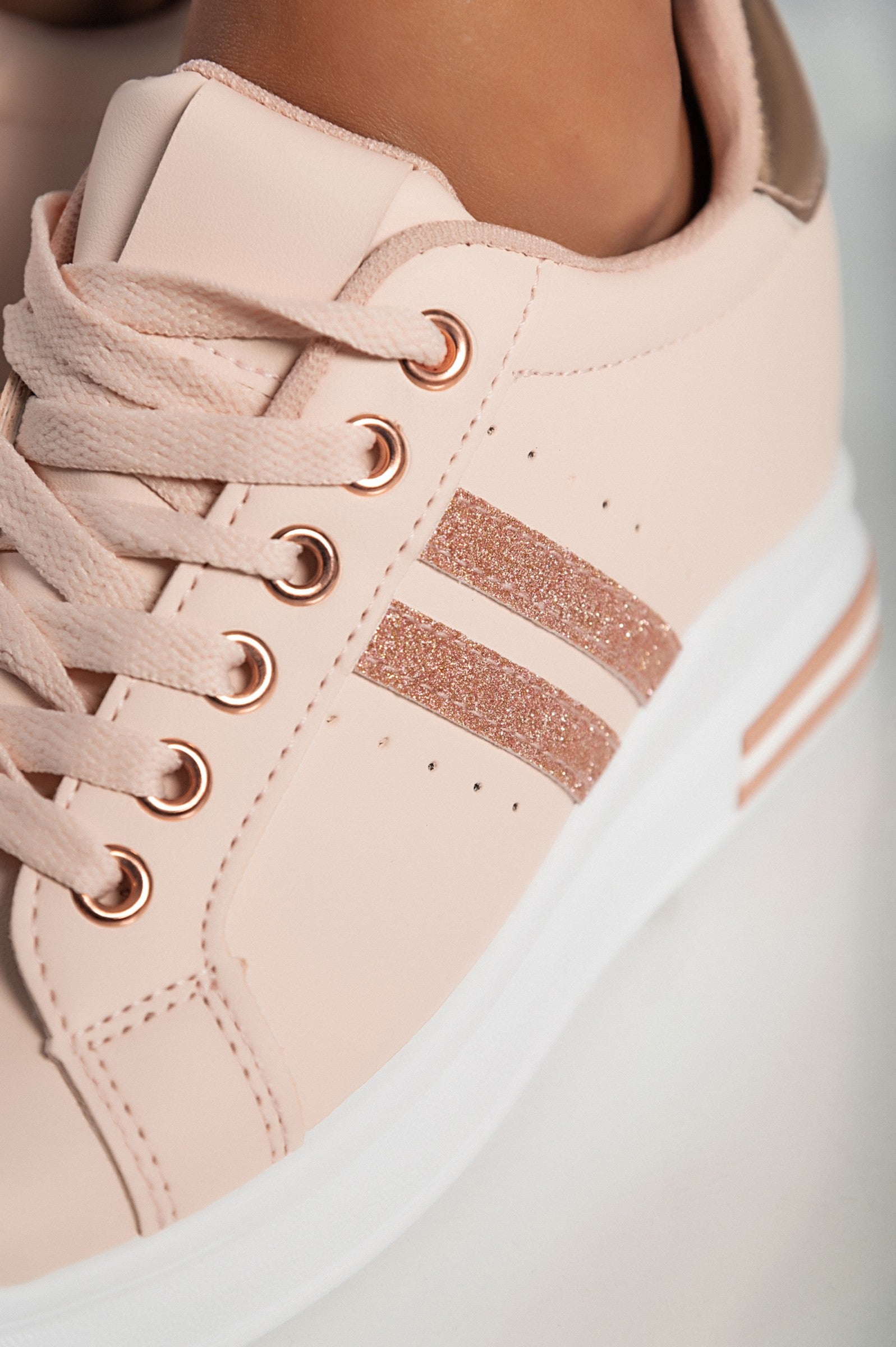 Stylish pink faux leather sneakers with round toe and laces, featuring a raised sole for added comfort.