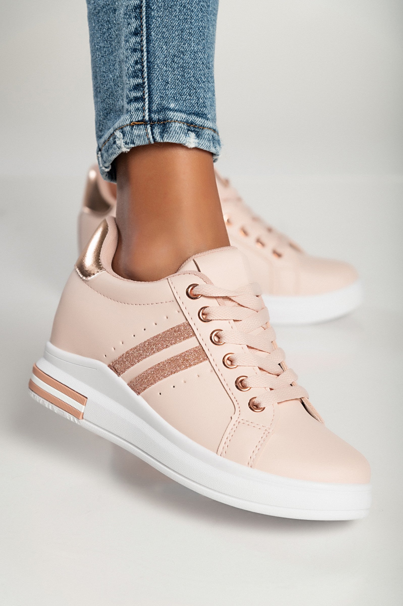 Stylish pink faux leather sneakers with round toe and laces, featuring a raised sole for added comfort.