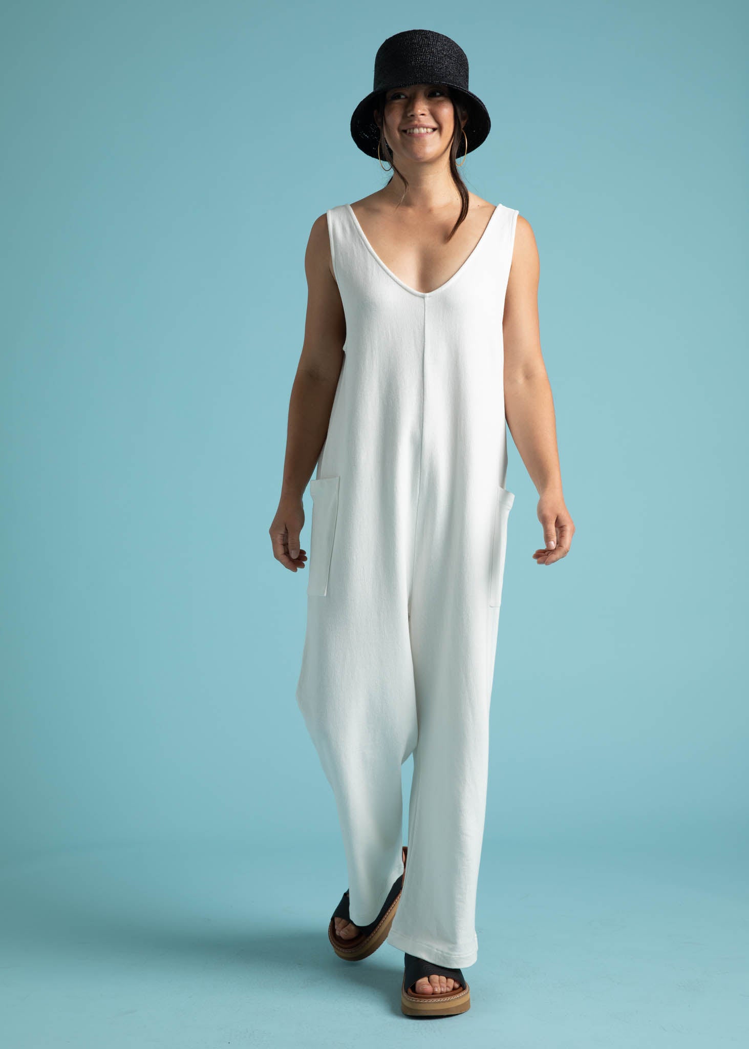 A stylish natural-colored Field Day Romper made from eco-friendly cotton jersey, featuring a relaxed fit, v-neck design, and patch side pockets.