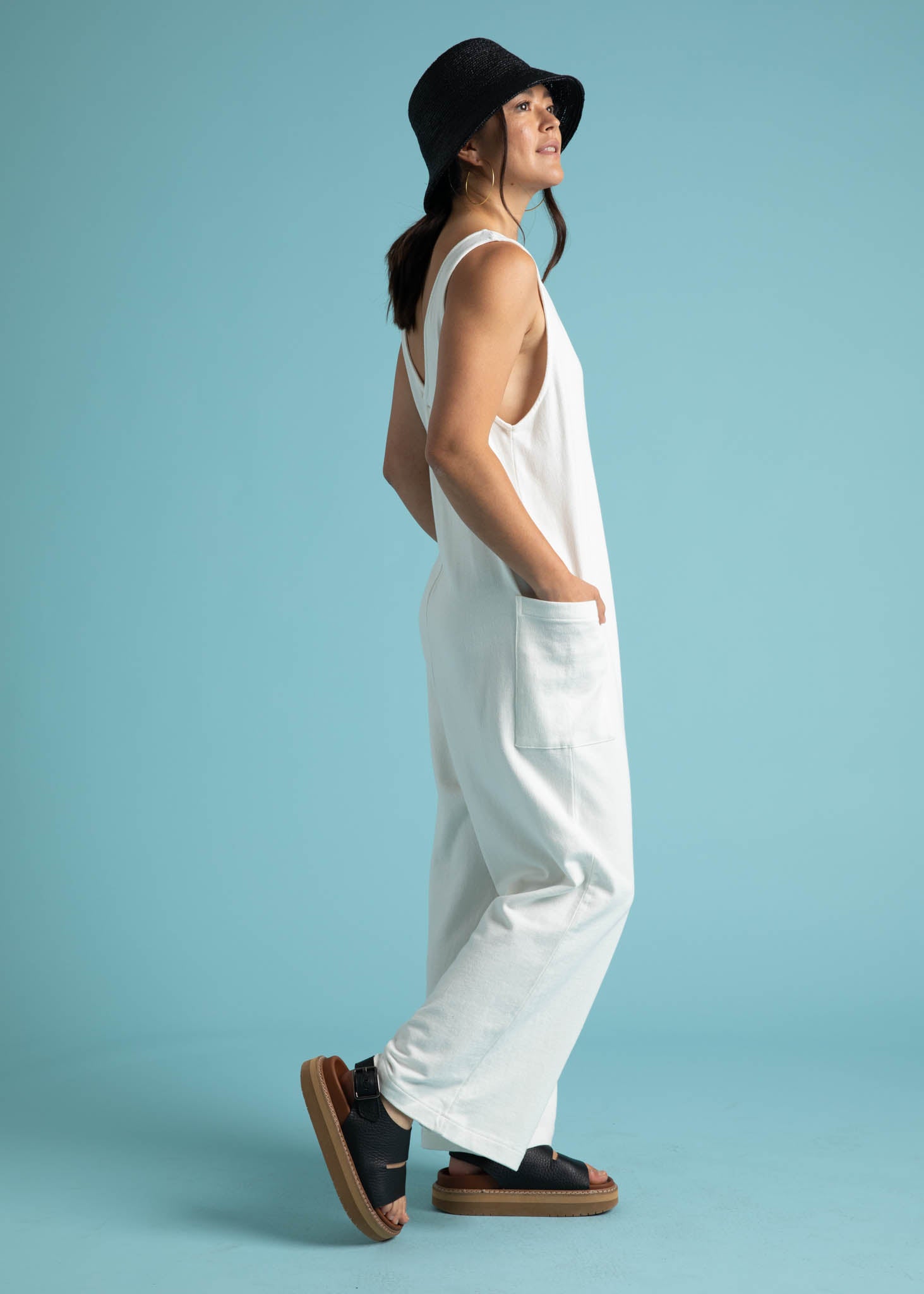 A stylish natural-colored Field Day Romper made from eco-friendly cotton jersey, featuring a relaxed fit, v-neck design, and patch side pockets.