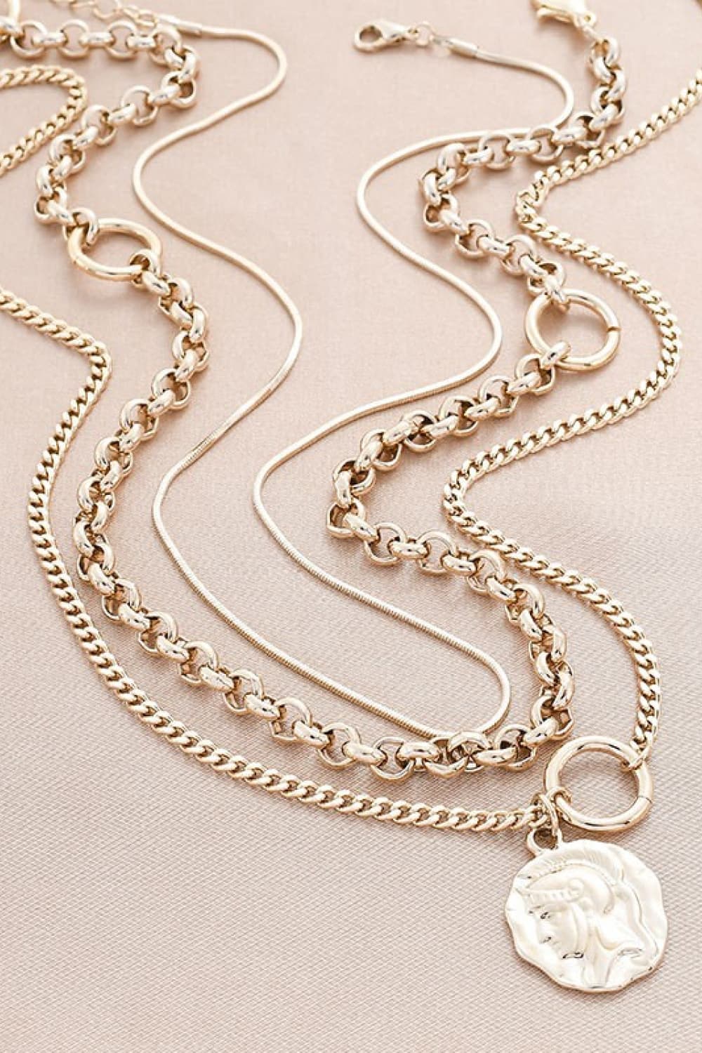 A stylish three-piece necklace set featuring a modern figure pendant, crafted from alloy and copper, showcasing its elegant design.