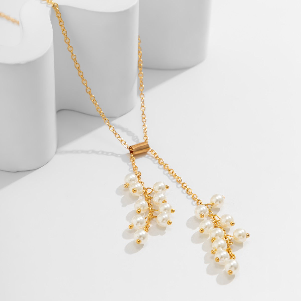 Elegant gold necklace adorned with imitation pearls, featuring a secure metal carabiner closure.