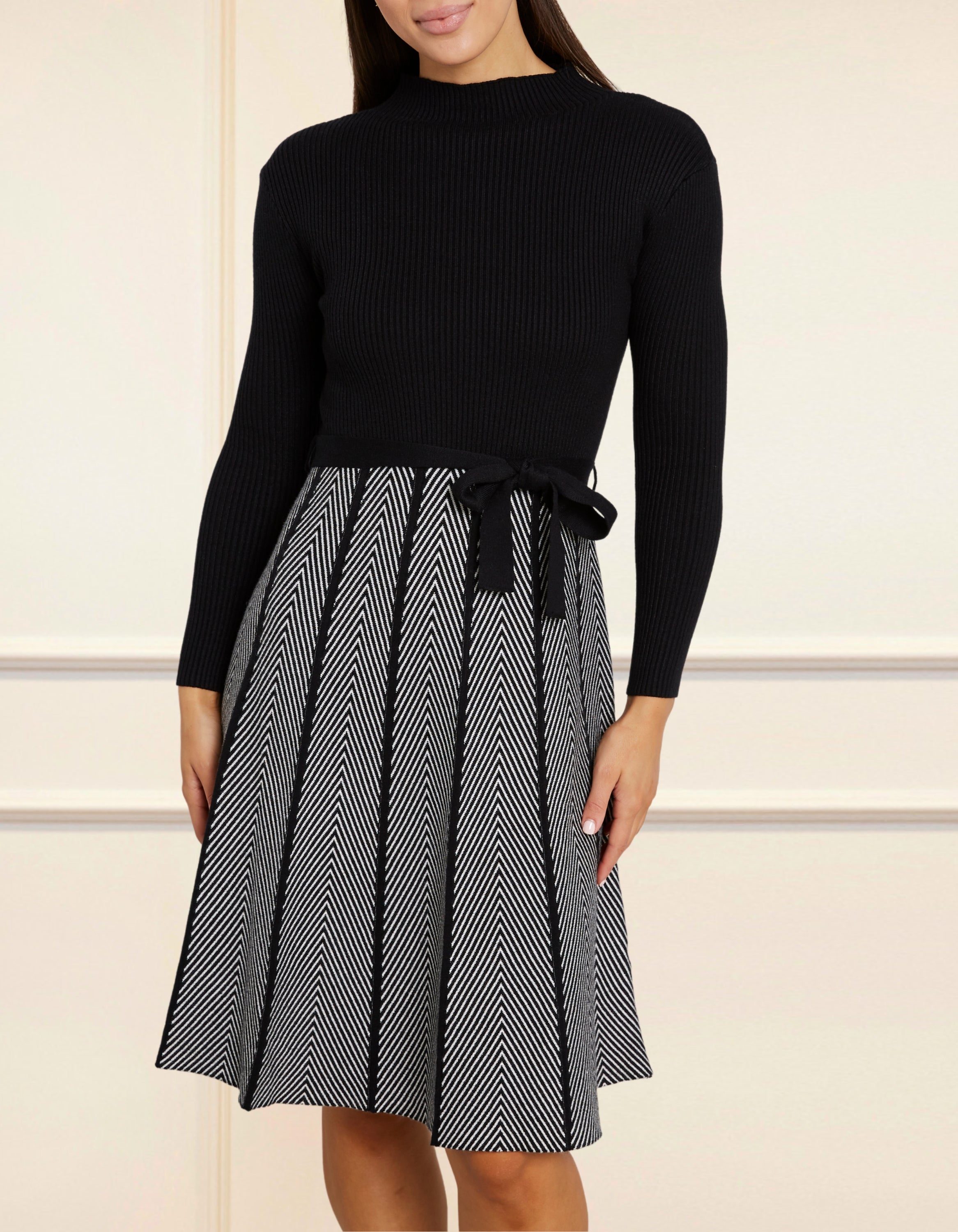 Fiola Dress featuring a solid black ribbed top and herringbone knit skirt, showcasing a stylish winter outfit.