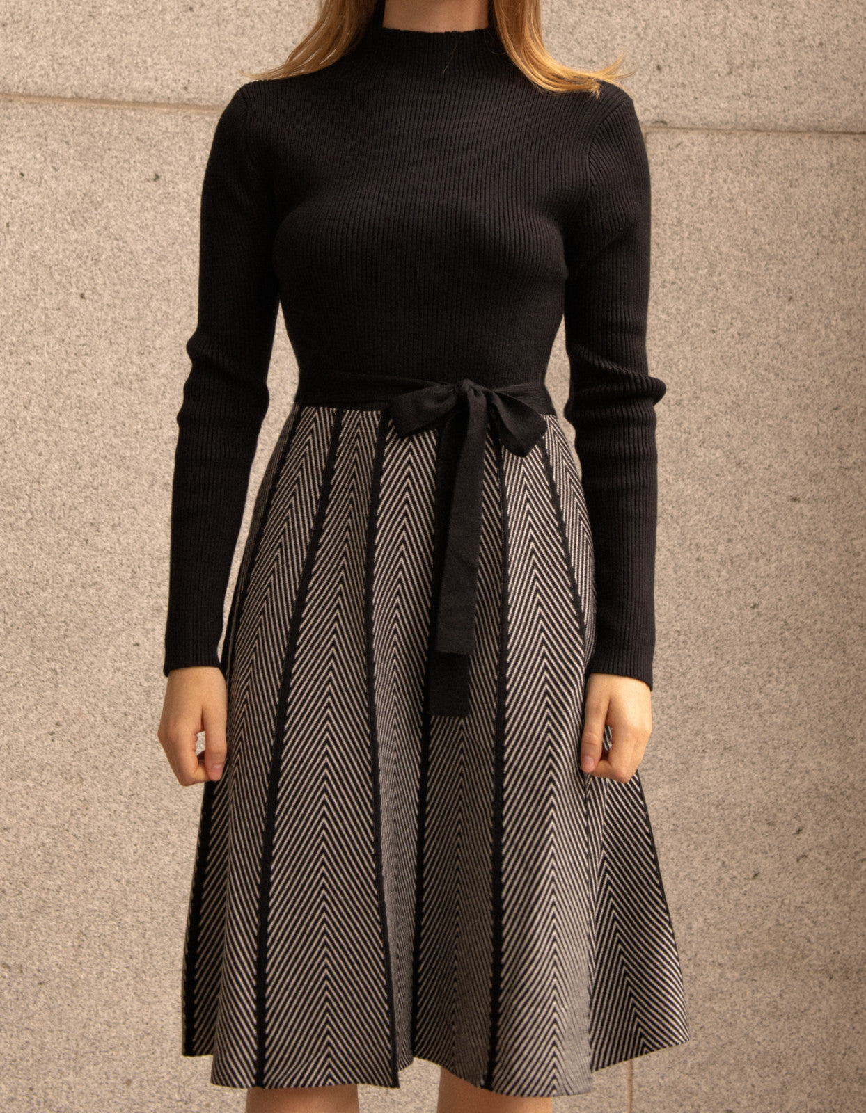 Fiola Dress featuring a solid black ribbed top and herringbone knit skirt, showcasing a stylish winter outfit.