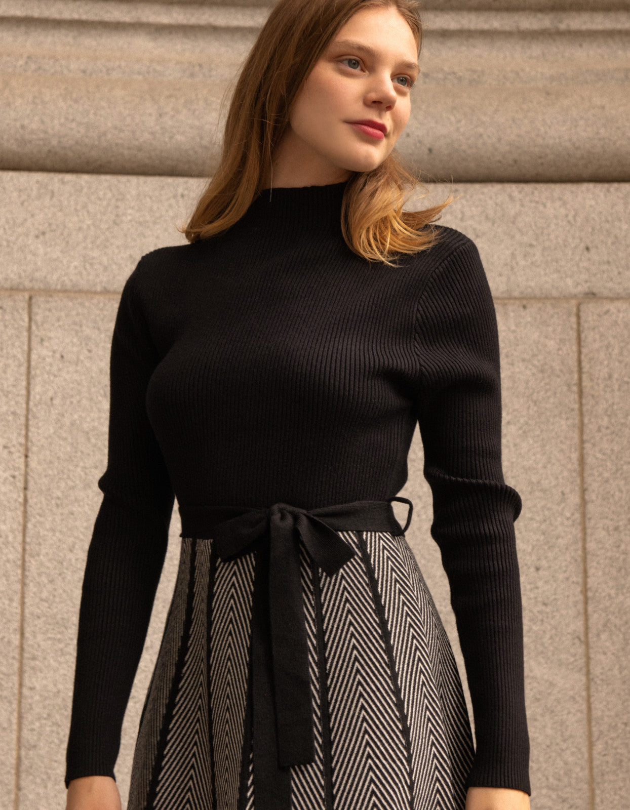 Fiola Dress featuring a solid black ribbed top and herringbone knit skirt, showcasing a stylish winter outfit.