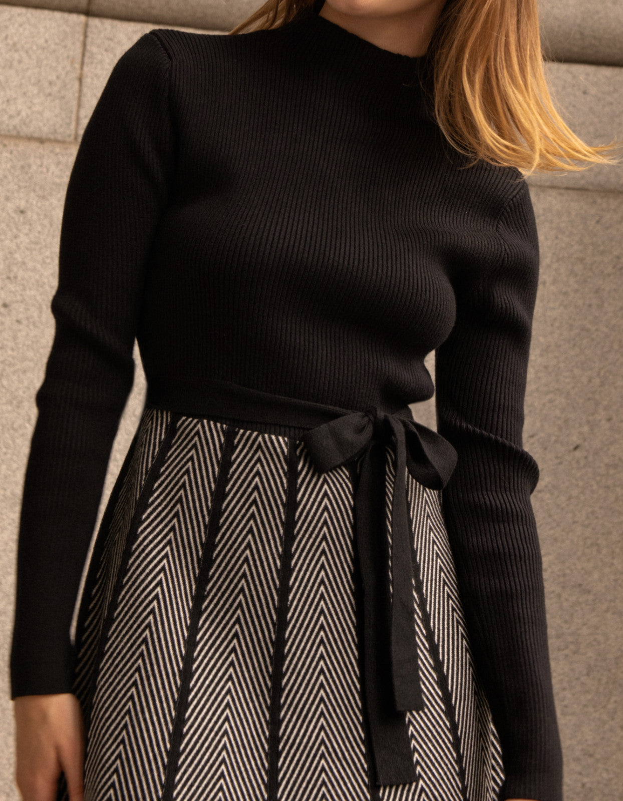 Fiola Dress featuring a solid black ribbed top and herringbone knit skirt, showcasing a stylish winter outfit.