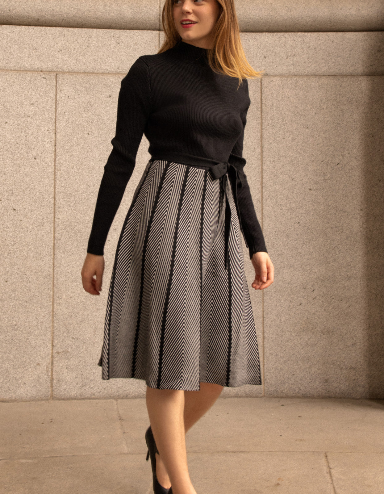 Fiola Dress featuring a solid black ribbed top and herringbone knit skirt, showcasing a stylish winter outfit.