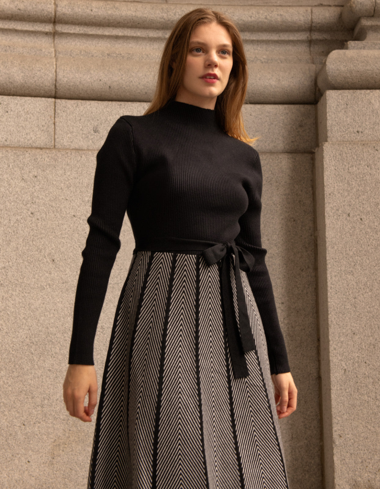 Fiola Dress featuring a solid black ribbed top and herringbone knit skirt, showcasing a stylish winter outfit.