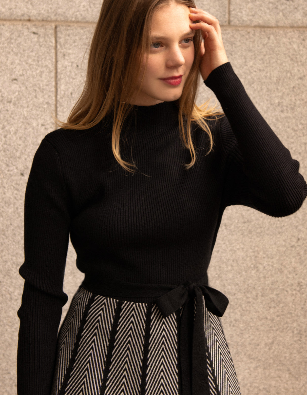 Fiola Dress featuring a solid black ribbed top and herringbone knit skirt, showcasing a stylish winter outfit.