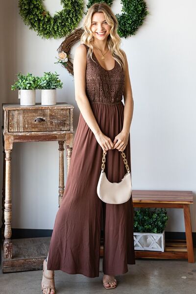 A stylish woman wearing the First Love Tie Back Sleeveless Slit Wide Leg Jumpsuit, showcasing its unique tie back design and flirty leg slit.