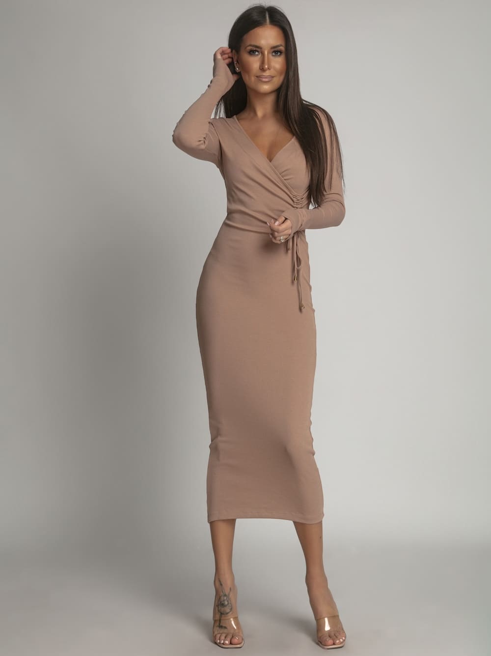 Fitted midi dress in cappuccino color with ruffles and envelope V-neck design, showcasing a stylish and elegant look.