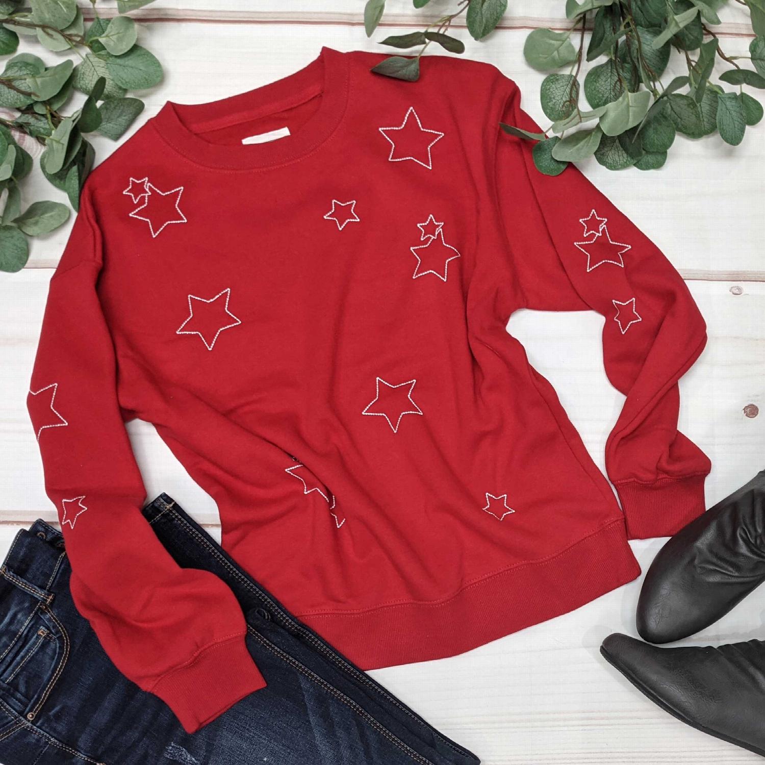 Fleece Basic Sweatshirt with Star Emb featuring an all-over star print in red, black, or white with grey outlines.