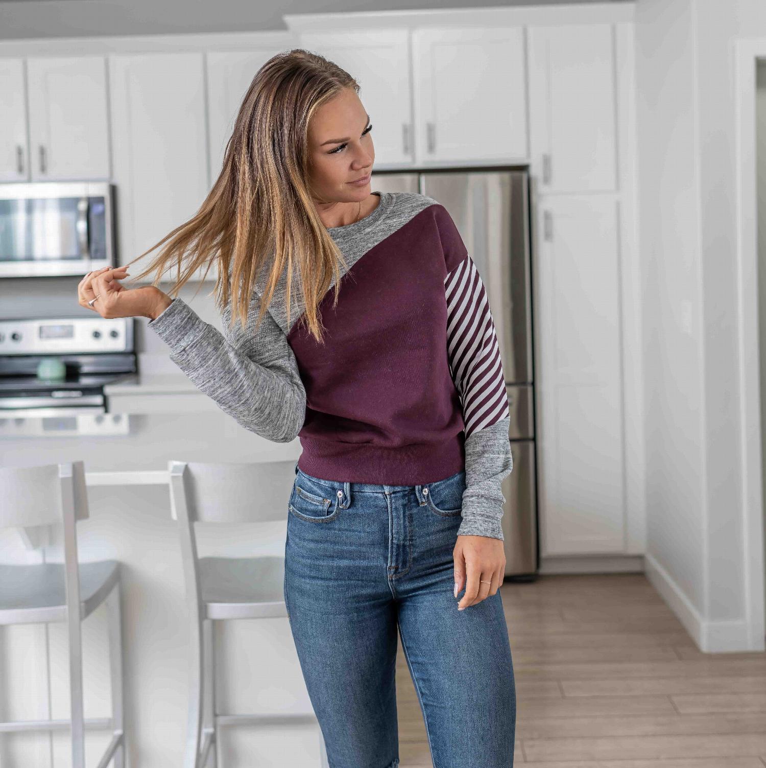 Fleece Color Block Crop Tee featuring asymmetrical color blocking and striped sleeve design in plum and grey.