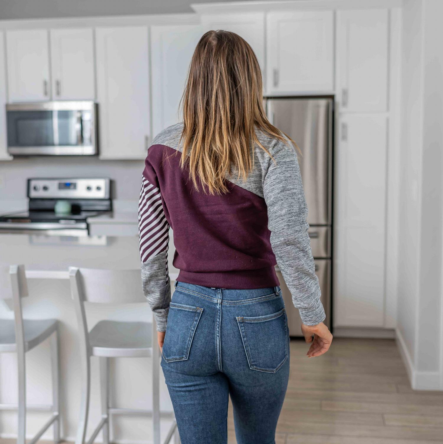 Fleece Color Block Crop Tee featuring asymmetrical color blocking and striped sleeve design in plum and grey.