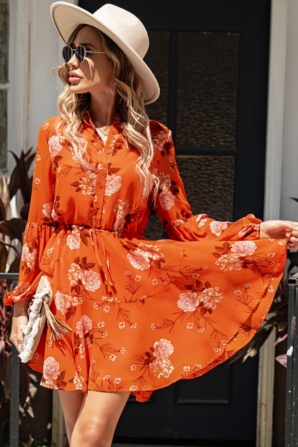 A stylish Floral Buttoned Puff Sleeve Tiered Dress featuring a floral pattern, balloon sleeves, and a mini length, displayed outdoors in a flat lay style.