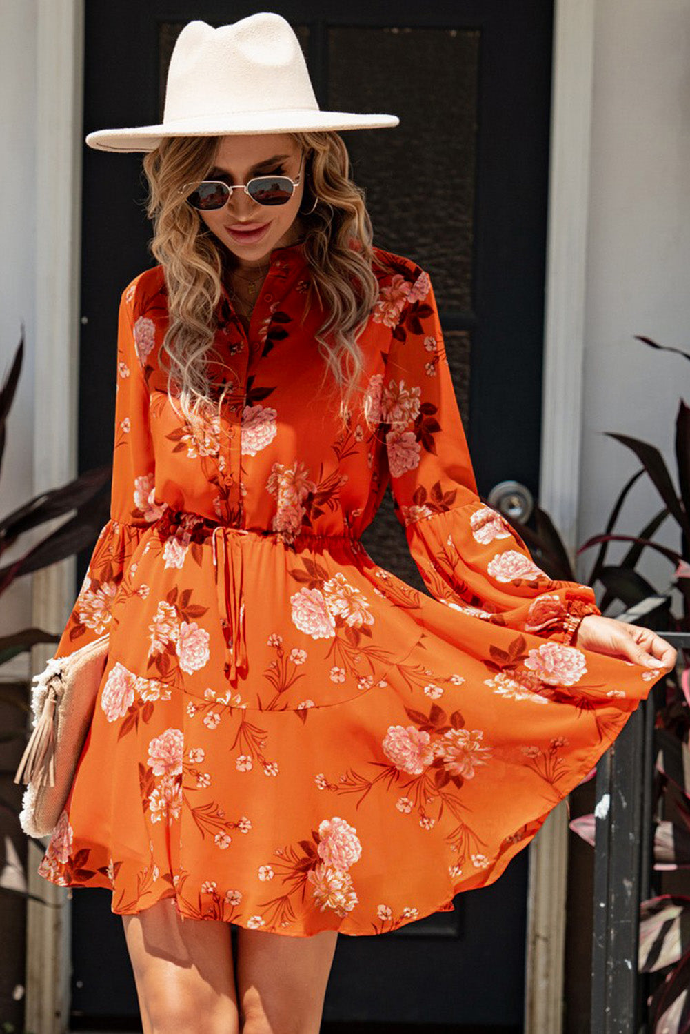 A stylish Floral Buttoned Puff Sleeve Tiered Dress featuring a floral pattern, balloon sleeves, and a mini length, displayed outdoors in a flat lay style.