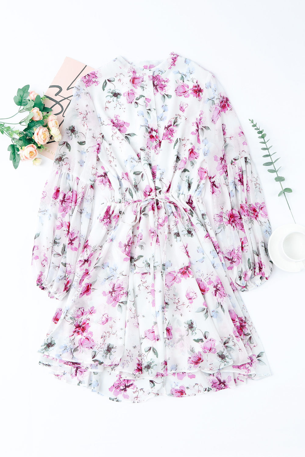 A stylish Floral Buttoned Puff Sleeve Tiered Dress featuring a floral pattern, balloon sleeves, and a mini length, displayed outdoors in a flat lay style.