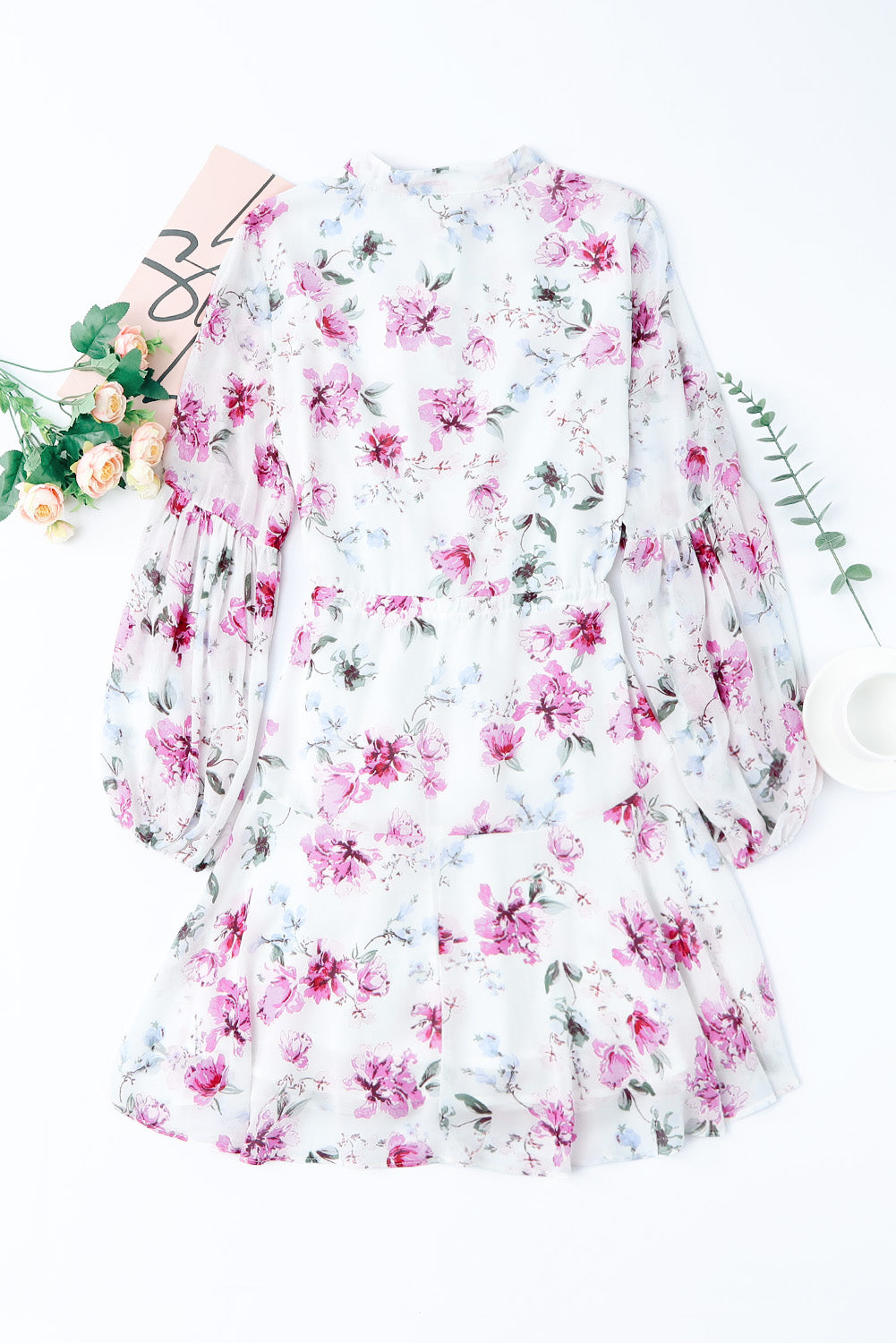 A stylish Floral Buttoned Puff Sleeve Tiered Dress featuring a floral pattern, balloon sleeves, and a mini length, displayed outdoors in a flat lay style.