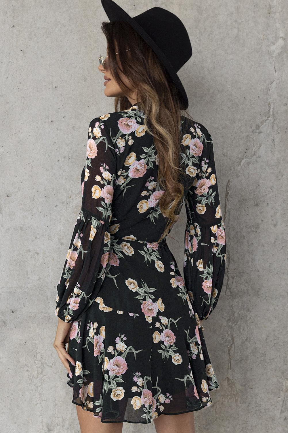 A stylish Floral Buttoned Puff Sleeve Tiered Dress featuring a floral pattern, balloon sleeves, and a mini length, displayed outdoors in a flat lay style.